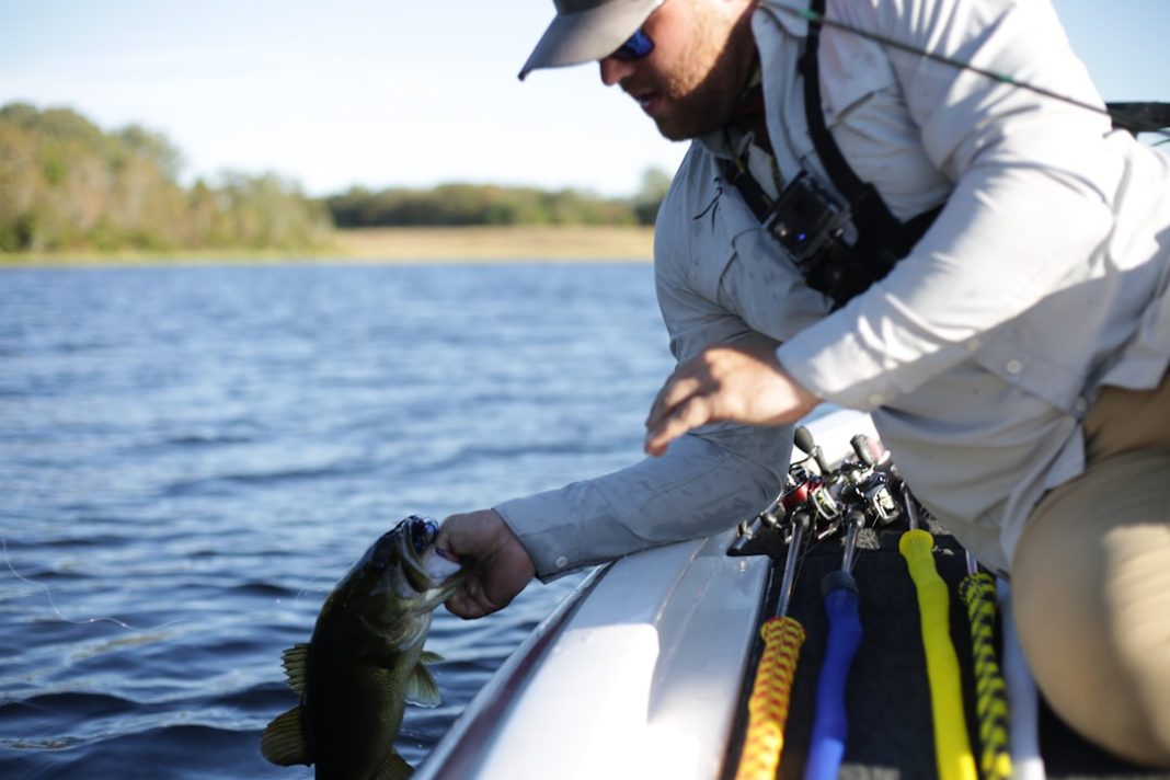 Фото: Richard R на Unsplash (https://unsplash.com/photos/a-man-holding-a-fish-while-sitting-on-a-boa